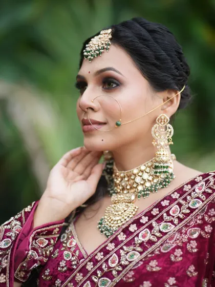Another angle of this stunning bridal look, highlighting the large nath and the detailed embroidery of the lehenga.