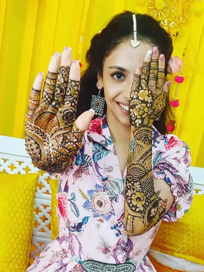 A happy bride is the best reward. Here's a client showing off her intricate engagement mehendi, a mix of traditional figures and floral patterns that we designed together.