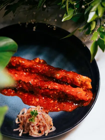 My Chicken Lasooni Seekh is packed with bold garlic flavor. The seekhs are coated in a rich, tangy red sauce and served with a side of spiced onions for a complete flavor experience.