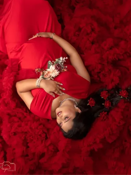 The vibrant red gown creates a beautiful contrast, making this a powerful and unforgettable portrait. This overhead view is one of my favorite ways to capture a mama's serene glow.