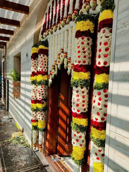 A side view of a main door decorated with thick flower pillars. The morning sun casting shadows makes the decoration look even more beautiful.
