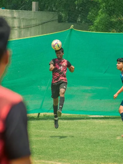 A player skillfully heads the ball, demonstrating an important aerial skill.