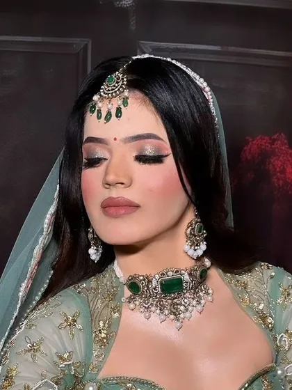 A bride wearing a mint green lehenga with a matching Kundan choker and maang tikka. This pastel combination is a fresh and modern choice for a wedding.