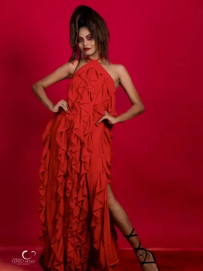 A full-length shot that captures the grandeur and drama of the red ruffled gown.
