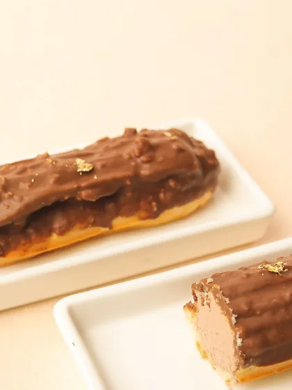A close-up of our Rocher eclair, showing the rich hazelnut crunch and velvety éclair filling.