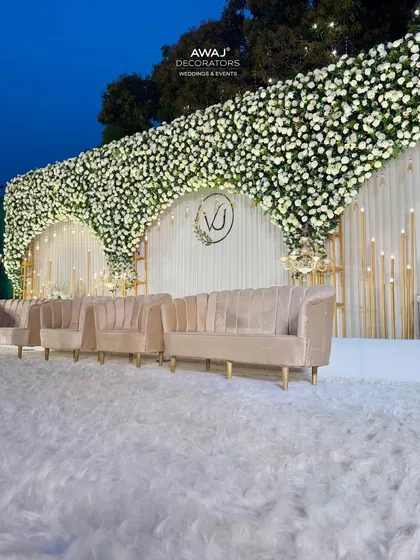 A side view of the white floral stage, highlighting the plush, modern sofas and the texture of the faux fur rug, adding a layer of comfort and luxury.