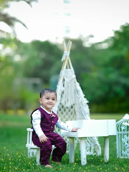 A sweet, smiling portrait of the birthday boy at his outdoor piano setup.