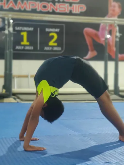 The back bridge, or wheel pose, is a key flexibility and strength exercise. This student is working on his form during a basics correction session.