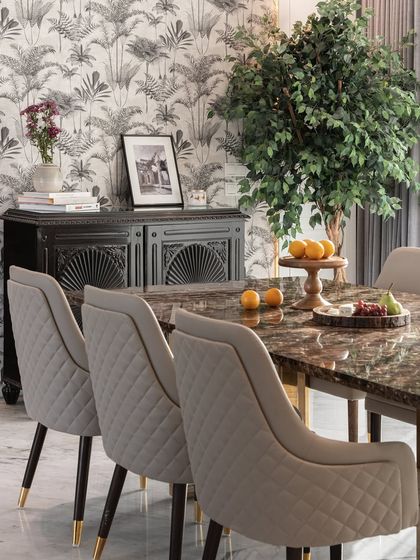 This dining area setup shows our approach to blending styles. A vintage-inspired black cabinet stands against a bold, tropical wallpaper, creating a dynamic and personalized space for dining.
