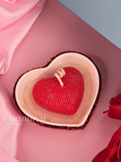 A textured red heart candle in a glitter-rimmed dish, for a bit of Valentine's sparkle.