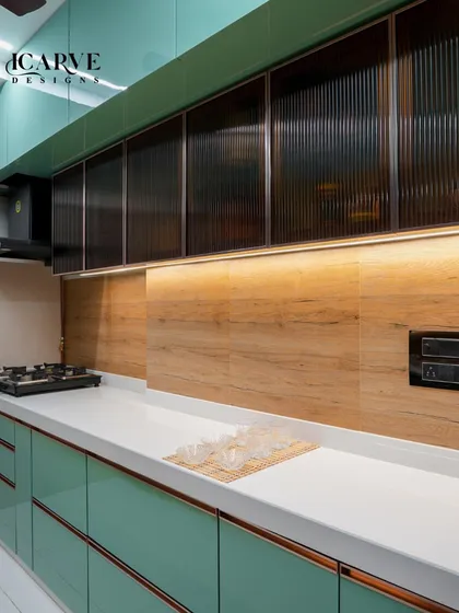 A glimpse into a sleek, modern modular kitchen. We used a refreshing mint green laminate for the cabinets, paired with a clean white countertop and warm under-cabinet lighting to make the space both stylish and highly functional for daily cooking.