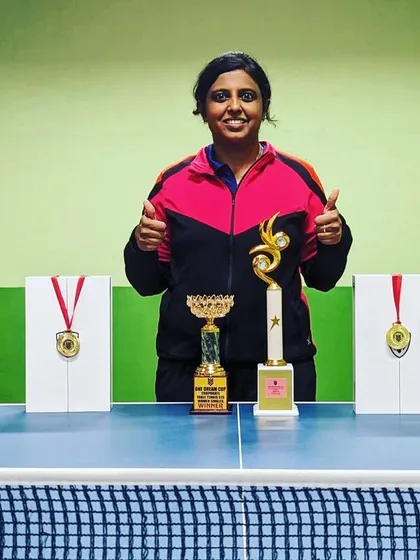 Ashwini B M showcasing her trophies after winning the Women's singles and Mixed doubles titles at the One Dream all India Mixed Corporate Table Tennis Tournament.