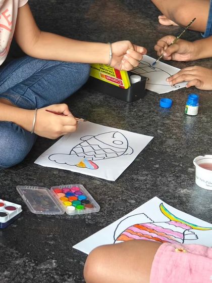 A close-up of children painting their props, showing the focus and detail they put into their work.