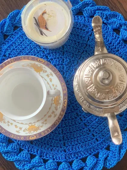 The blue placemat with the braided border, styled for a chic tea time. It's large enough to be used as a centerpiece or a tea mat.