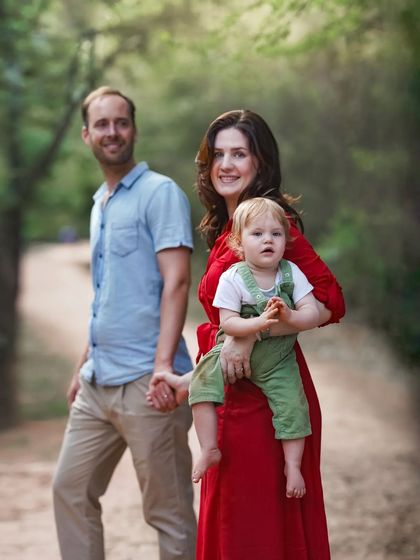 A candid family moment captured outdoors. The natural interaction and genuine smiles make this portrait feel authentic and full of life, a perfect snapshot of this family's love.