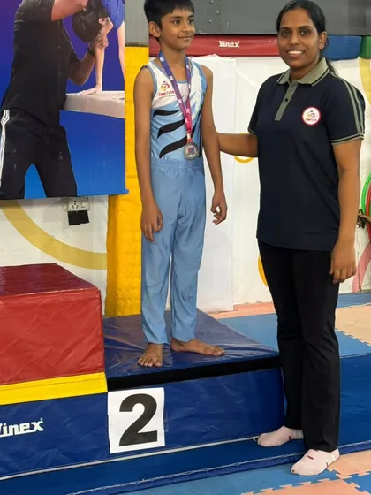 Celebrating a second-place finish. Every spot on the podium is a significant achievement, reflecting the gymnast's hard work and the coach's expert guidance.