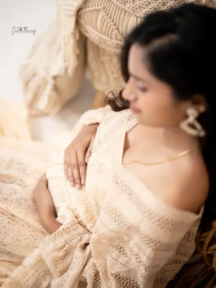 Another beautiful angle from our boho session, capturing the mother-to-be in a moment of quiet reflection. The intricate details of the lace dress and decor are highlighted here.