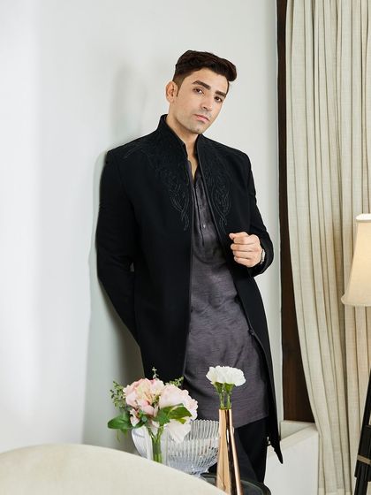 Paired with a grey textured kurta, the black Indo-Western jacket offers a sophisticated, layered look. It's an offbeat and elegant choice for any evening celebration.
