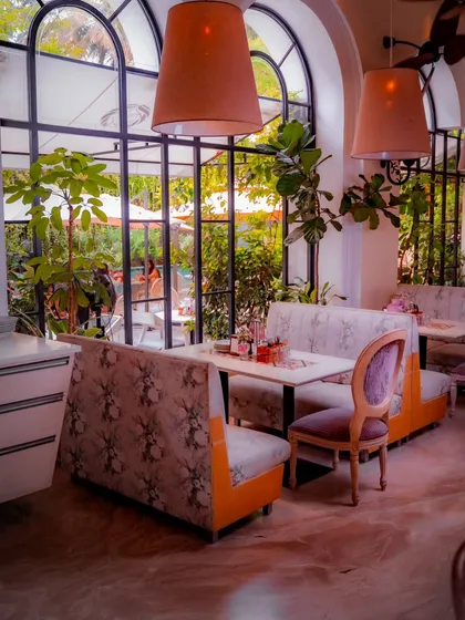 Floral-patterned booths and soft lighting create a charming and whimsical dining area, perfect for a leisurely brunch or a romantic dinner.