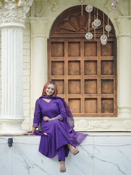 A relaxed pose on a marble ledge with a classic window backdrop.