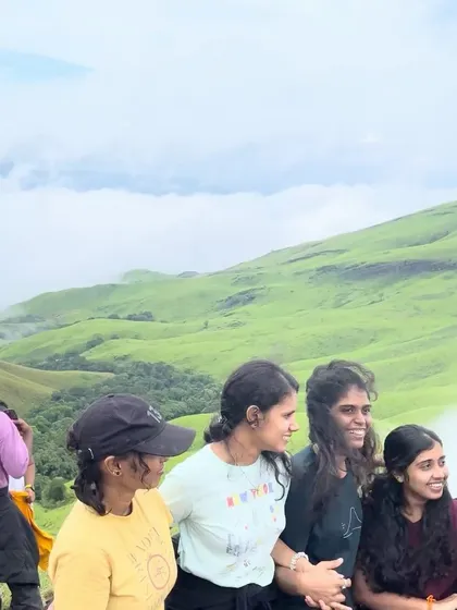 Friends posing together with the misty Netravathi hills in the background.