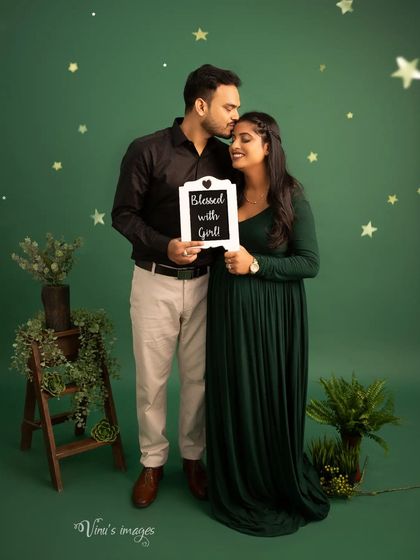 A joyful announcement. The "Blessed with a Girl" sign and the father-to-be's tender kiss on his wife's forehead make this a truly special memory.