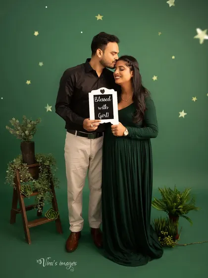 A joyful announcement. The "Blessed with a Girl" sign and the father-to-be's tender kiss on his wife's forehead make this a truly special memory.
