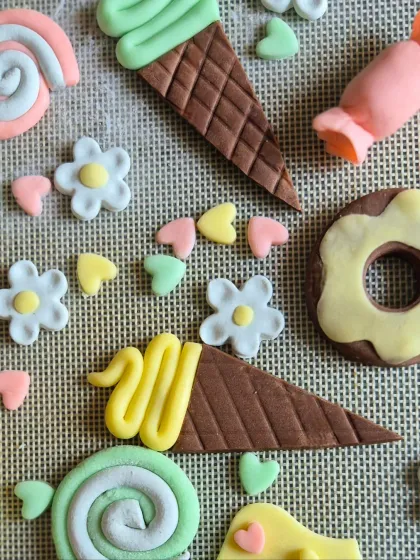 A flat lay of the handmade fondant toppers for a candy and ice cream themed cake, showing the little details that make each cake special.
