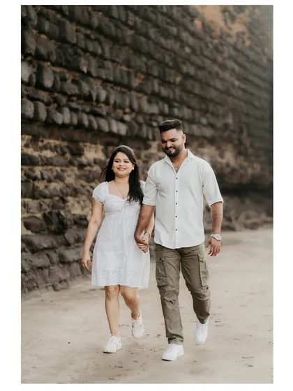 A relaxed walk along the beach, capturing a casual and happy moment between the couple.