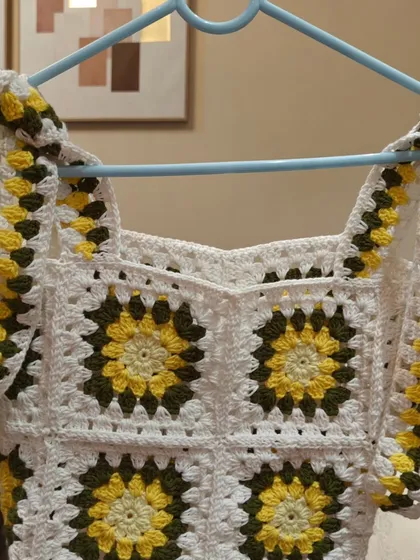 A detailed shot of the sunflower top's neckline and straps. The sweetheart neckline is formed by the shape of the granny squares themselves.