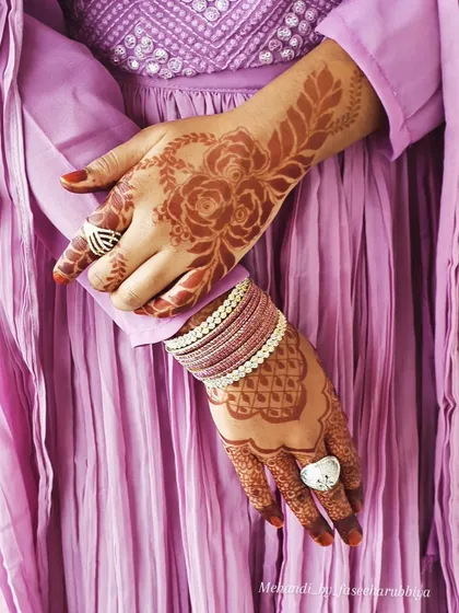A different pose showcasing the beautiful contrast of the henna stain against the client's purple outfit.