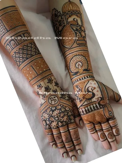 This design is a beautiful showcase of peacock motifs. They are featured on the palms and forearms, surrounded by intricate floral and geometric patterns.