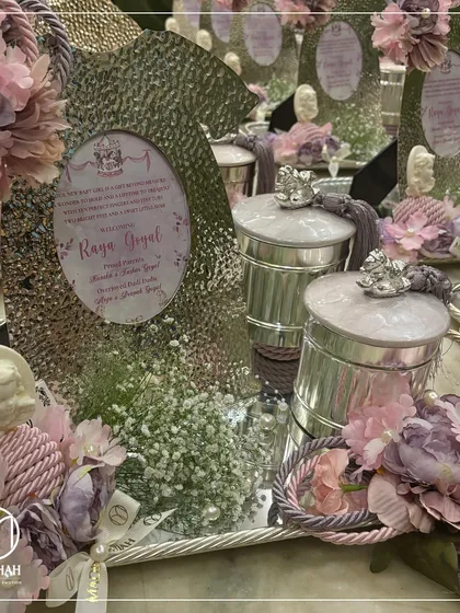 Another perspective of the 'Raya Goyal' announcement hamper, focusing on the intricate details. The silver tray holds the personalized frame, keepsake jars, and is accented with pearls and silk flowers.