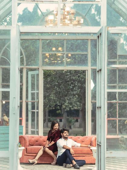 A beautiful wide-angle shot of a couple in a glasshouse, using the architectural lines to frame them perfectly in this pre-wedding photo.