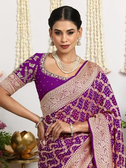 A close-up of the royal purple Bandhani saree, paired with an embroidered blouse and a pearl necklace.