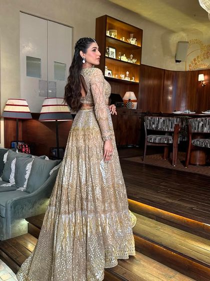 The full look is pure elegance. The hairstyle perfectly balances the grandeur of the golden lehenga.