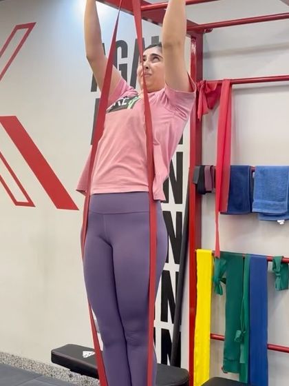 A patient performs a band-assisted pull-up, a key exercise in her journey to recover from a serious neck injury. This demonstrates the progressive strengthening that is central to our rehabilitation philosophy, helping rebuild function safely.