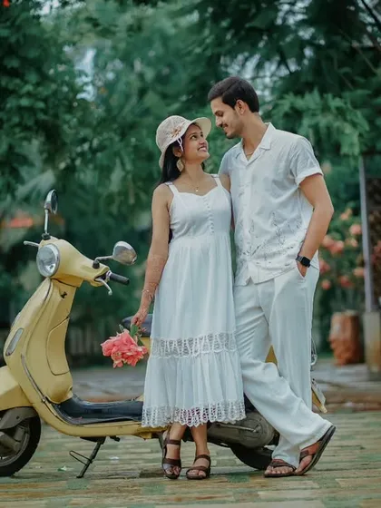 A retro-themed pre-wedding shoot with a classic yellow scooter. Suchita and Om Prakash look adorable and stylish in their coordinated white outfits.