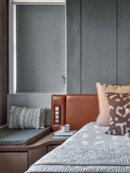 Details from a master bedroom design. The headboard paneling incorporates a hidden door, and a custom wooden piece acts as a unique handle for a concealed storage unit.