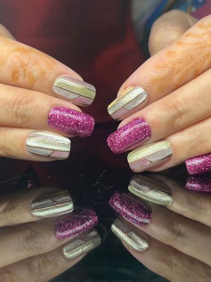 A full view of the eye-catching magenta glitter and metallic striped nails.