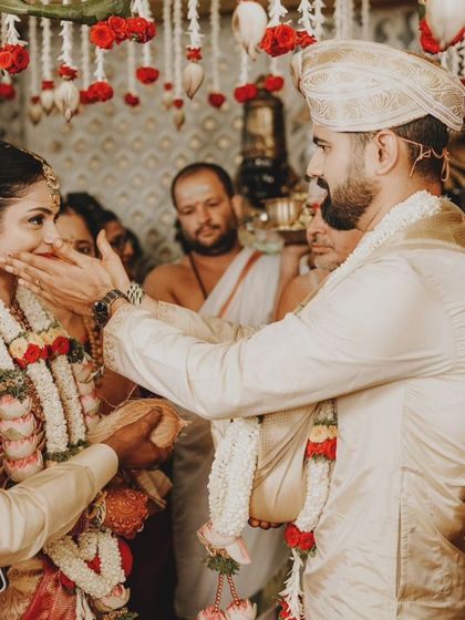 A playful and tender moment as the groom blesses his bride during the ceremony.