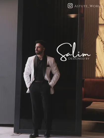 A client in a classic white tuxedo jacket with a black shawl lapel, paired with a black shirt. This monochrome look is effortlessly cool and sophisticated.