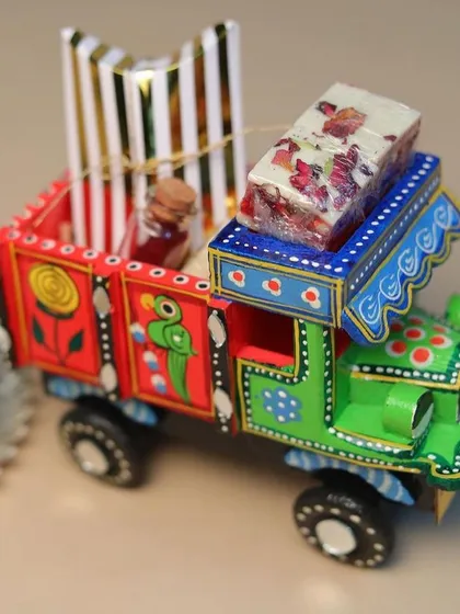 A side view of the colourful hand-painted truck hamper, showing the intricate details.