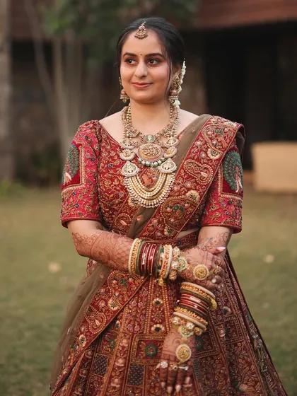 A real bride looking radiant with a gentle, low updo. This hairstyle is perfect for supporting heavy jewellery and a dupatta without feeling too severe.