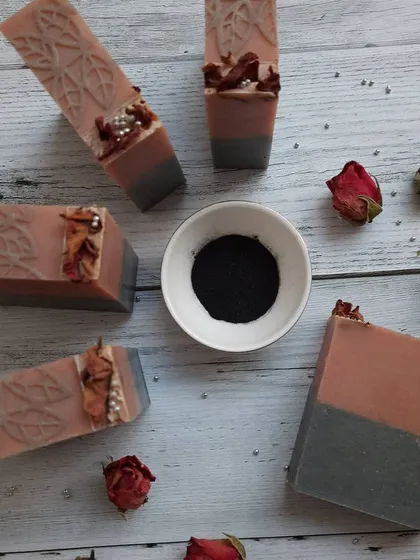 This is my Charcoal Rose soap, a customer favorite. I arrange each bar with dried rosebuds and a sprinkle of charcoal powder, showcasing the natural French pink clay and activated charcoal that work to gently detoxify your skin.