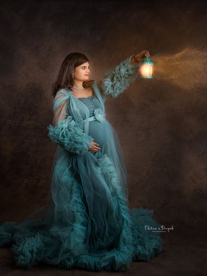 Lighting the way. This artistic shot uses a lantern prop to create a warm glow, adding a touch of mystery and magic to this maternity portrait.