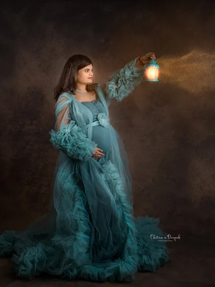 Lighting the way. This artistic shot uses a lantern prop to create a warm glow, adding a touch of mystery and magic to this maternity portrait.