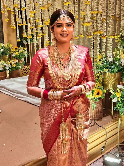 Posing against the festive decor, the bride looks absolutely stunning. Her makeup is flawless and long-lasting, perfect for a long day of celebrations.