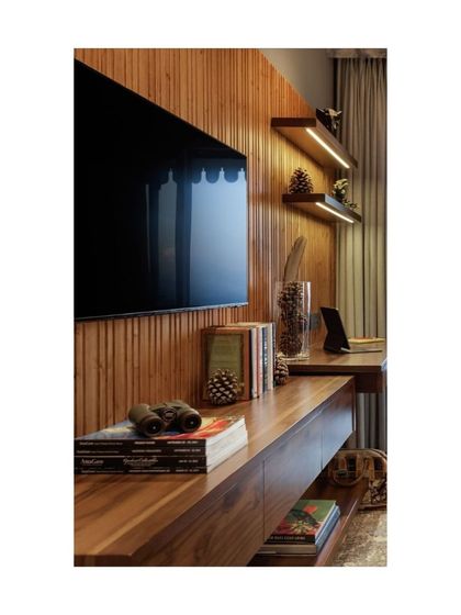 Another example of shelving from Valley of Dreams, this time integrated into a TV and desk unit. The warm wood and under-shelf lighting create a functional and atmospheric space for both entertainment and work.