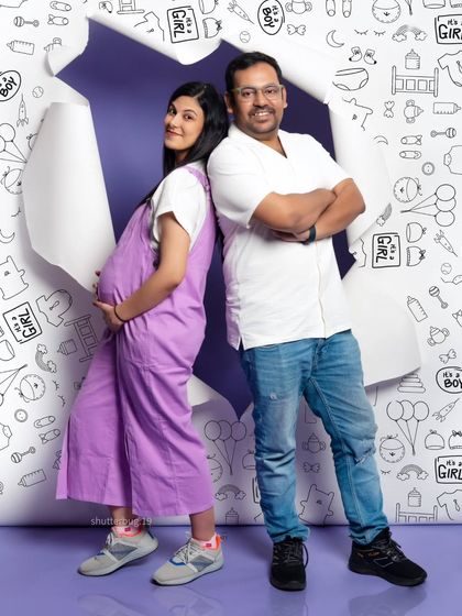 A playful pose from our torn paper backdrop series. The couple stands back-to-back, showing off their fun personalities and the mom's growing baby bump.